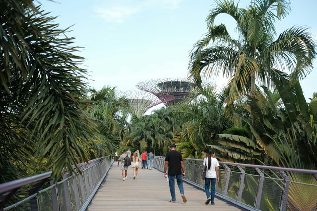 People walking on a bridge towards futuristic domes