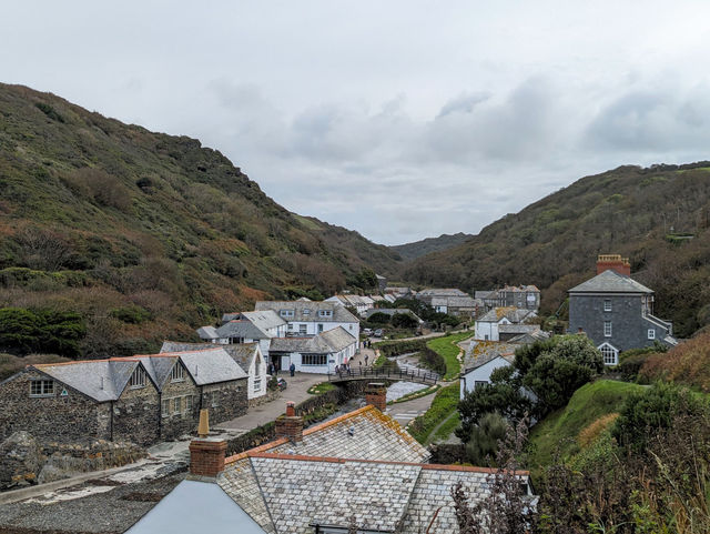 Charming rooftops and lush hills of Boscastle, a picturesque village in Cornwall, England's serene landscape.