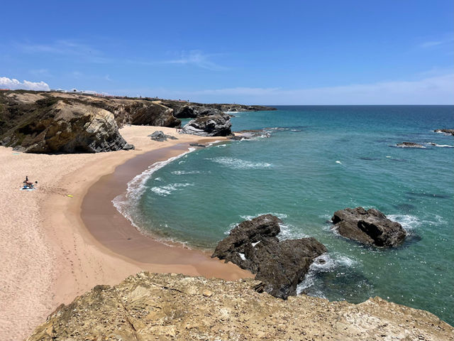 Beautiful rocky shore on the Alentejo coast with turquoise waters and clear skies.