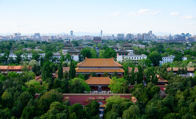 A stunning aerial view of ancient Chinese architecture with Beijing's city skyline in the background.