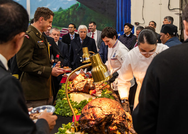 Sailors serve distinguished visitors during a formal reception held aboard Nimitz-class aircraft carrier USS George Washington (CVN 73) while anchored off the coast of Lima, Peru,