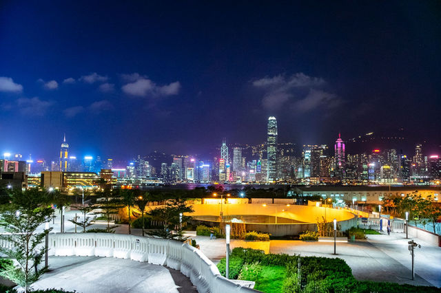 Stunning view of Hong Kong's illuminated cityscape from a park at night, capturing urban vibrancy.