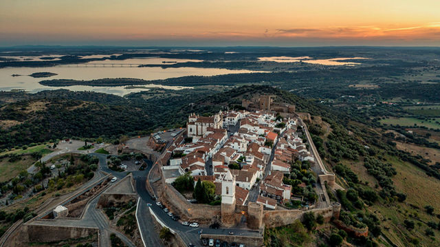 Stunning aerial shot of Monsaraz village in Alentejo, Portugal during sunset. Scenic landscape and historic architecture.