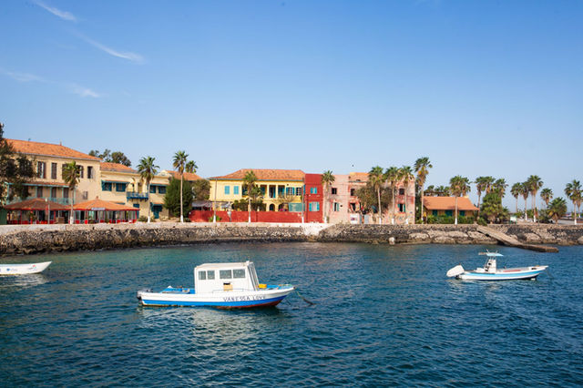 Scenic view of colorful colonial buildings and boats on Goree Island, Senegal.