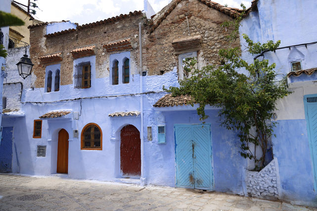 Vibrant blue facade of traditional houses in Chefchaouen's historic streets.