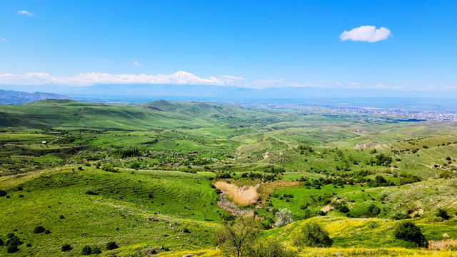 Explore the vibrant landscapes of Voghjaberd, Armenia with lush green hills and distant mountains.