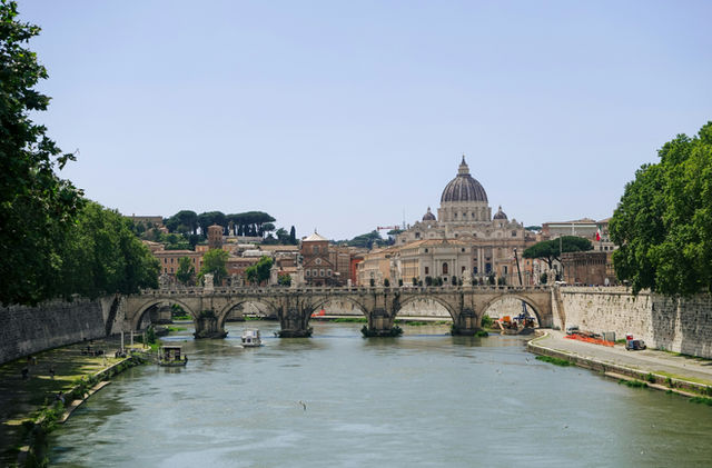 St. peter's basilica and a stone bridge over a river.