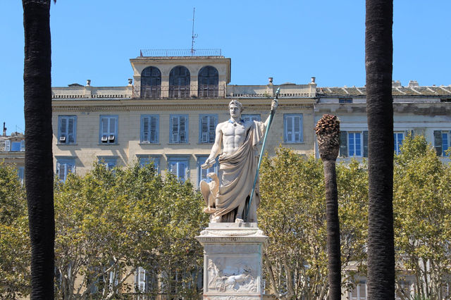A stunning statue of Napoleon Bonaparte in Bastia, Corsica, set against historical architecture.
