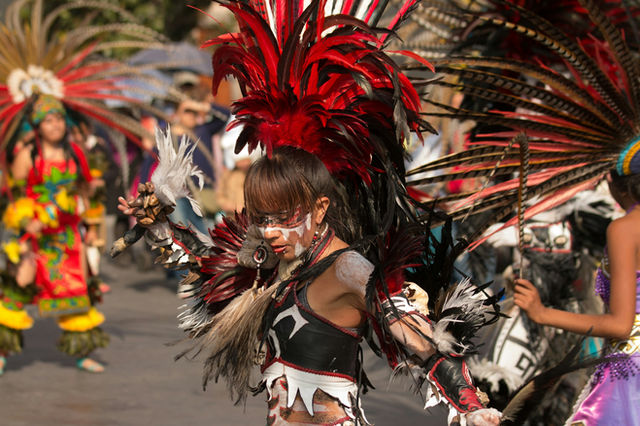 Scarlet Mexica headdress and face paint on a young dancer