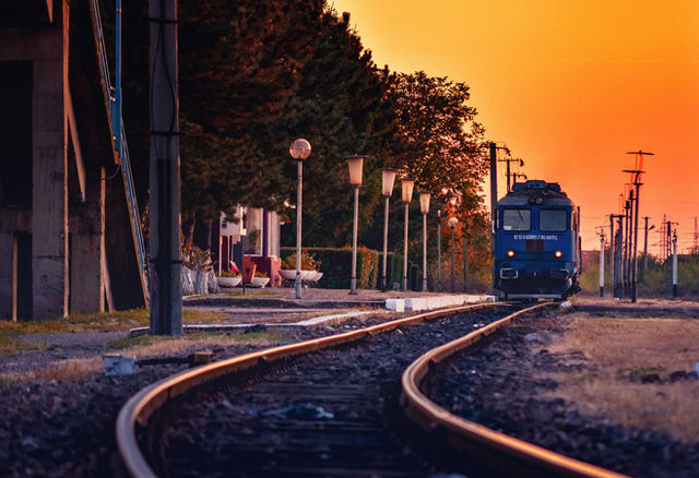 blue train on rail road during sunset