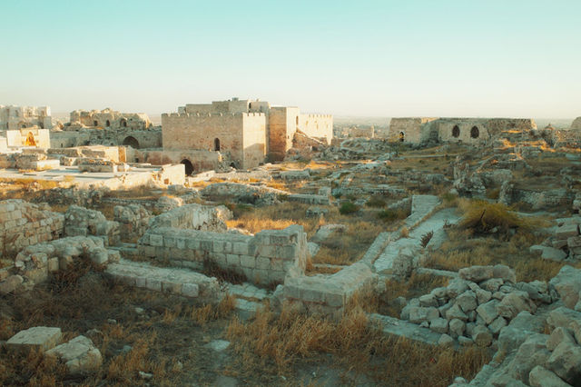 Explore the historic Aleppo Citadel ruins in Syria at sunrise, showcasing ancient architecture.