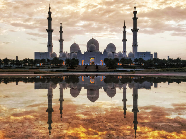Majestic Reflections of Shaik Zayed Grand Mosque and fiery golden sky captured from the Oasis of Dignity, Abu Dhabi, UAE. 
 
 The Oasis of Dignity has still water at it's center which gives you sple