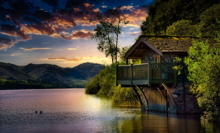 A picturesque boathouse along Ullswater Lake in England at sunset, with stunning mountain views.
