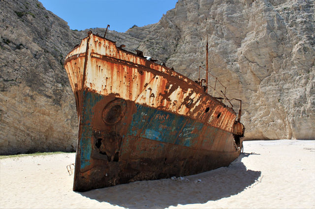 Iconic rusty shipwreck on the sandy shores of Navagio Beach, Zakynthos, under the summer sun.