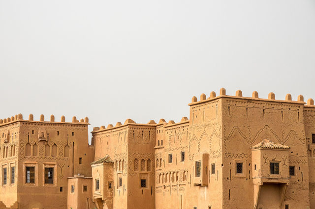 Explore a historic adobe fort in Morocco with unique architecture and desert backdrop.