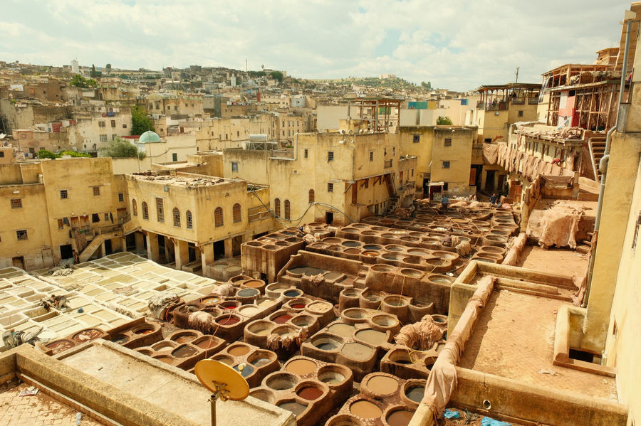 View of the historic tanneries in Fes, Morocco, showcasing traditional leather tanning vats and architecture.