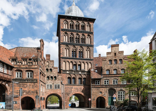 Iconic Gothic-style Burgtor tower in Lübeck, Germany, showcasing stunning medieval architecture under a clear sky.