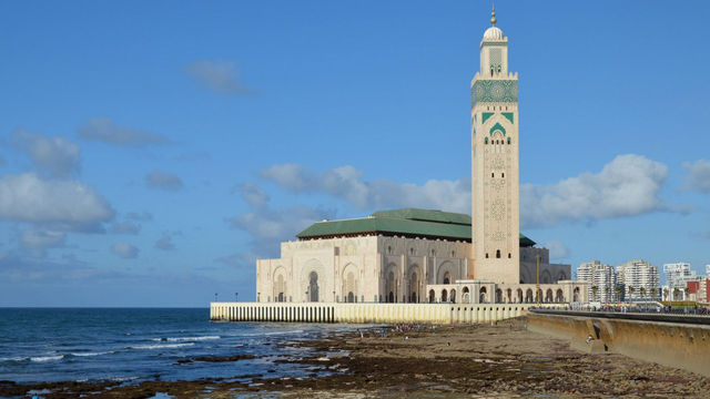 Stunning view of the Hassan II Mosque in Casablanca by the Atlantic coast under a clear blue sky.