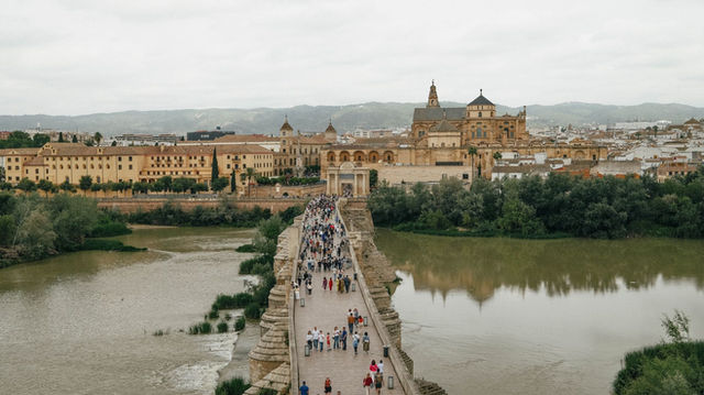 View of the busy Roman Bridge leading to the iconic Mosque-Cathedral in Córdoba, Spain.