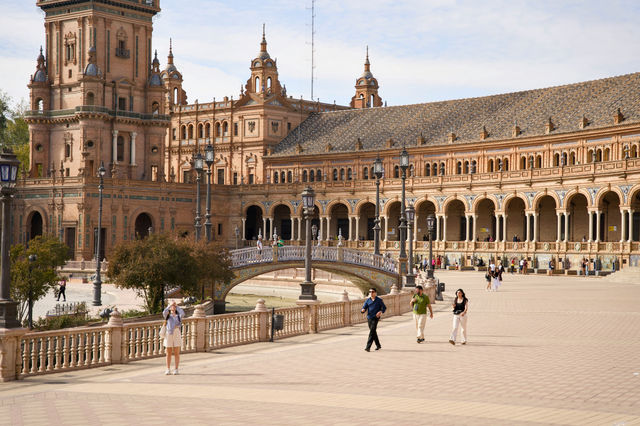 Grand plaza with ornate architecture and people walking.