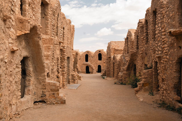 Explore ancient stone structures in the Tunisian desert, showcasing historical architecture.