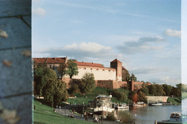Castle complex overlooking a river with trees
