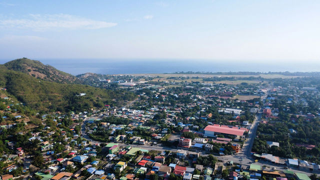 an aerial view of a small town with a mountain in the background