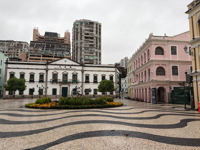 View of Senado Square in Macao featuring colonial architecture and wave-patterned pavement.
