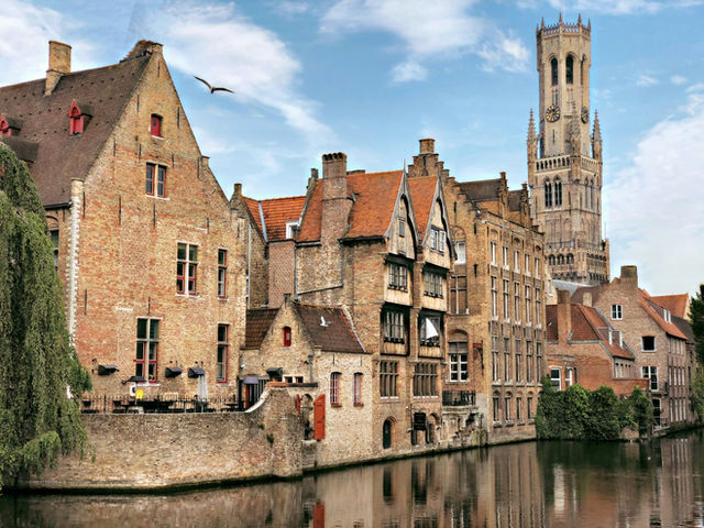 brown concrete building beside river during daytime