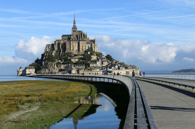 a castle on a hill with Mont Saint-Michel in the background