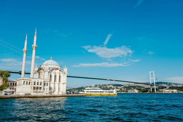 Mosque and bridge over blue water with boat