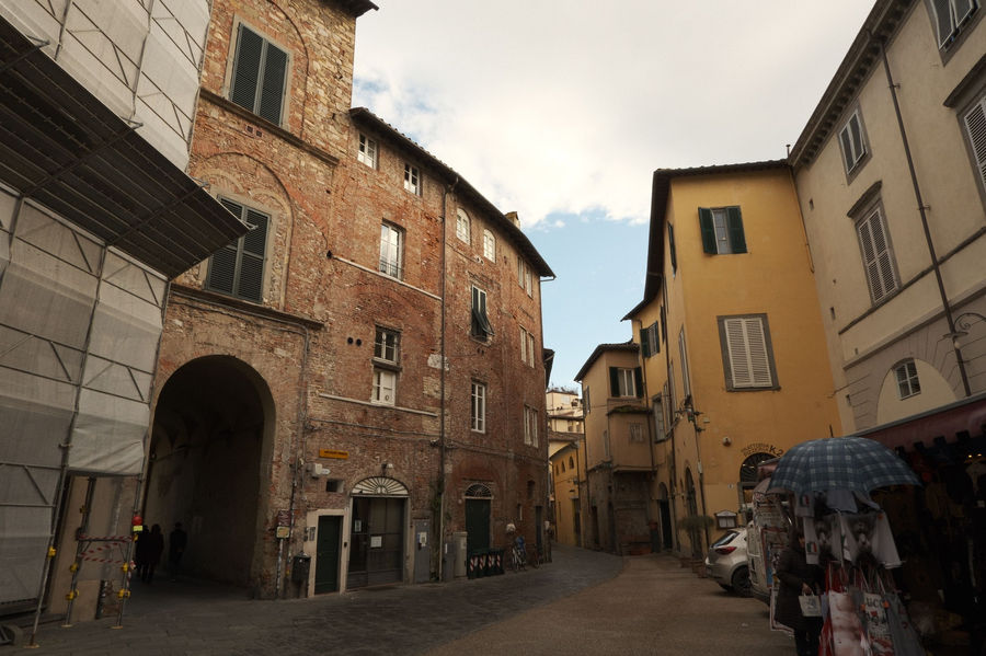 Explore a historic cobblestone street in Lucca, Tuscany, showcasing medieval architecture.