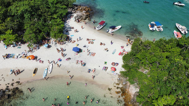 Tropical beach scene at Angra dos Reis with people enjoying summer activities.