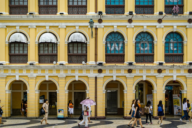 people near yellow building during daytime