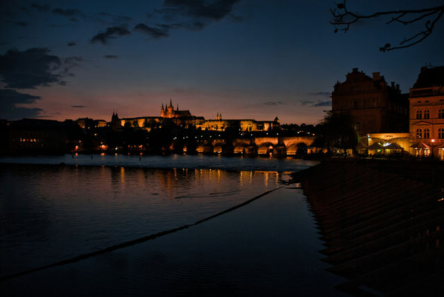 Cityscape with illuminated bridge and castle at dusk