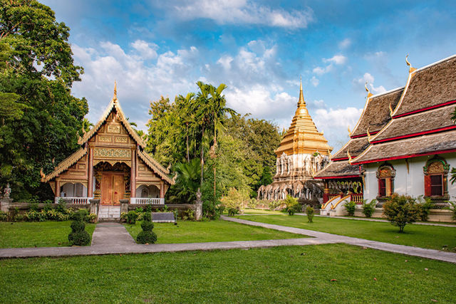 Bright, detailed view of Wat Chiang Man and lush gardens in Chiang Mai, showcasing Thai architecture and culture.