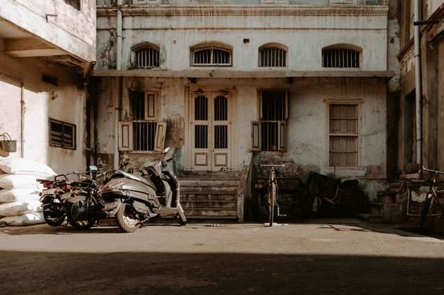 Urban scene showing an abandoned building and motorcycles in Ahmedabad, India.
