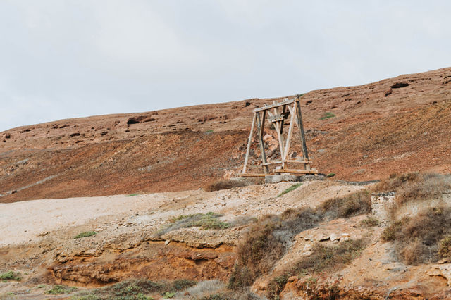 a rusted bridge sitting on top of a rocky hillside