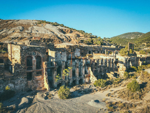 Aged brick construction at Montevecchio mining complex located on hill slope against cloudless blue sky in Sardinia