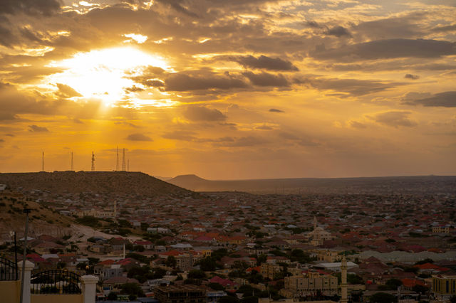 The sun descends, painting the city in warm, golden light. A spectacular sunset view.
