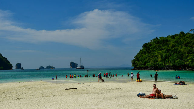 A dramatic limestone cliff rises from the deep blue sea at Poda Island, Thailand, showcasing the raw natural beauty and iconic seascape of this tropical destination.