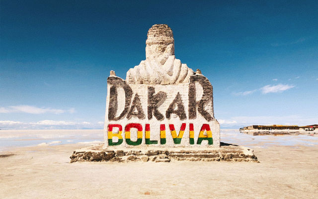 Stone monument at Salar de Uyuni celebrating the Dakar Rally in Bolivia's remote desert landscape.