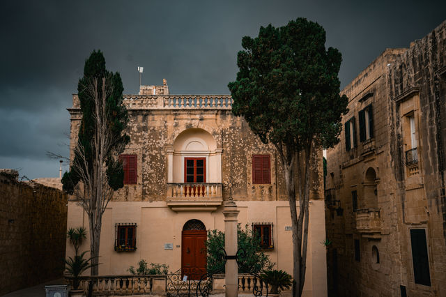 Old stone building with red doors and shutters