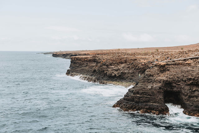 a large body of water next to a rocky cliff