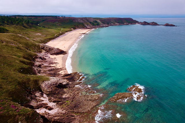 Scenic aerial view of Brittany, France's rugged coastline and clear turquoise waters.