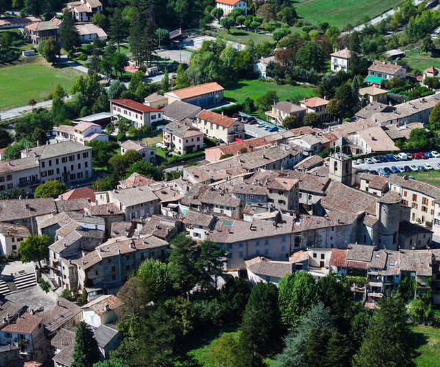 Explore the charming terracotta rooftops and lush greenery of Annot, a picturesque village in Provence, France, captured from above.