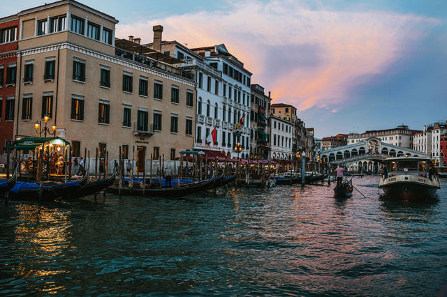 Beautiful view of Venice's Grand Canal with gondolas and historic buildings during twilight.