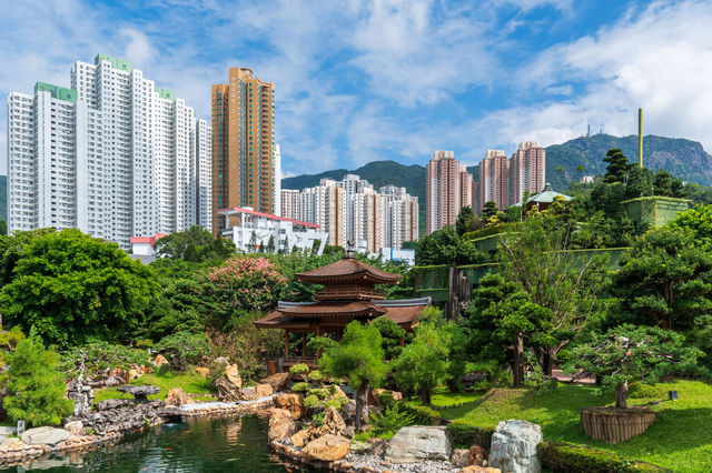 A traditional garden contrasts with modern skyscrapers in Hong Kong's vibrant cityscape.