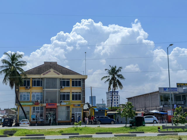 a yellow building with palm trees in front of it
