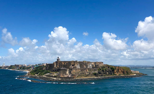 people standing on rock formation near sea under blue sky during daytime